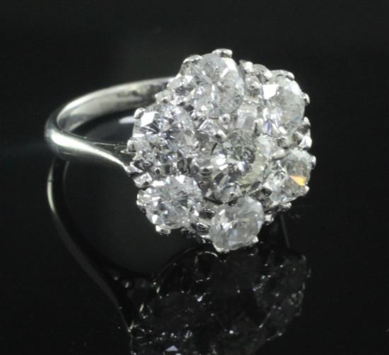 An 18ct white gold and seven stone diamond cluster flowerhead ring, size M.